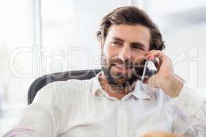 A smiling man passing a call