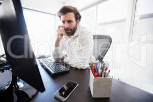 A pensive man looking at his computer