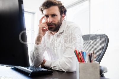 A pensive man looking at his computer