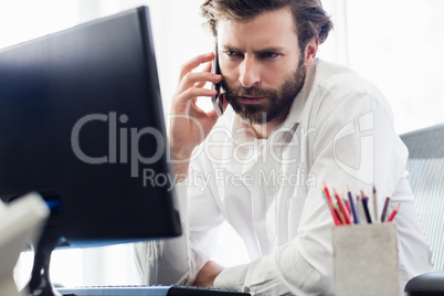 A man passing a call in front of his computer