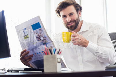 Businessman drinking coffee and reading newspapper