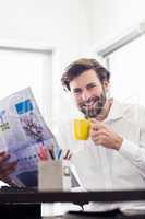 Businessman drinking coffee and reading newspaper