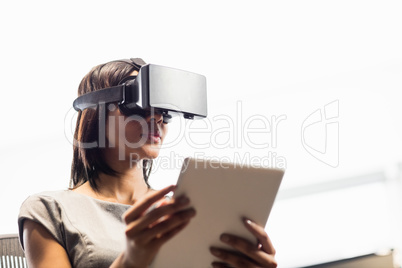 Businesswoman looking her tablet while using a virtual glasses