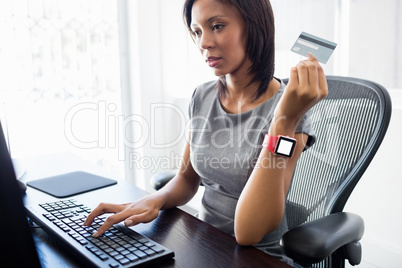 Businessman holding a credit card and looking her computer