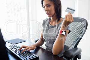 Businessman holding a credit card and looking her computer