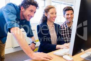 Businesspeople smiling and looking a computer