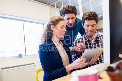 Businesspeople working and looking a tablet together