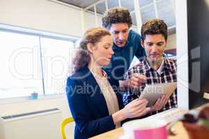 Businesspeople working and looking a tablet together