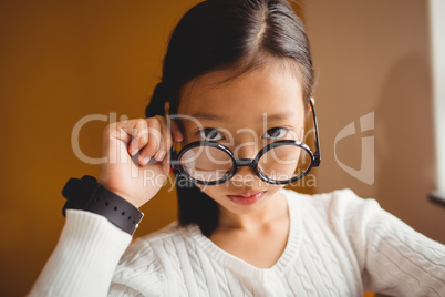 Schoolchild holding her glasses