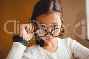 Schoolchild holding her glasses