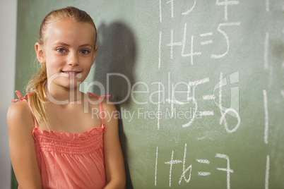 Girl standing in front of blackboard