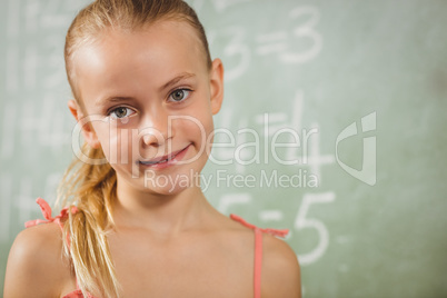 Girl standing in front of blackboard