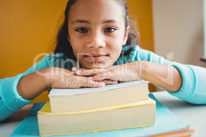 Girl leaning her head on pile of books