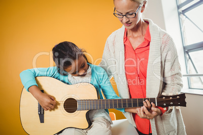 Girl learning how to play the guitar
