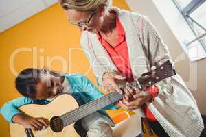 Girl learning how to play the guitar