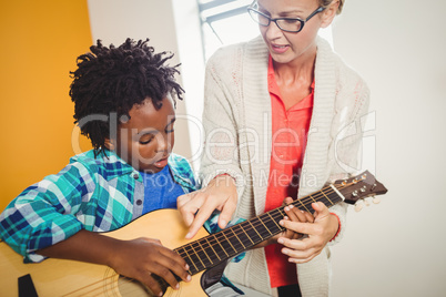 Boy learning how to play the guitar
