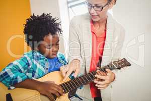 Boy learning how to play the guitar