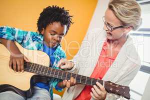 Boy learning how to play the guitar