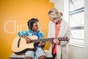 Boy learning how to play the guitar