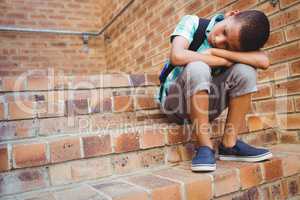 Sad schoolboy with his head on his knee