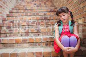 Sad schoolgirl siting in stairs