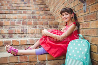 Smiling schoolgirl sitting in stairs