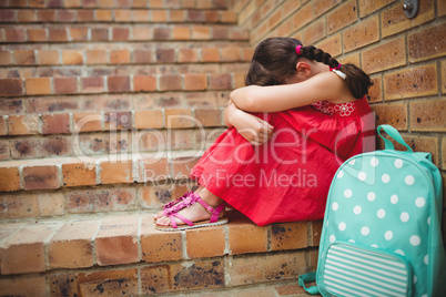 Sad schoolgirl with head into her legs