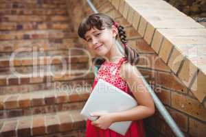 Brunette schoolgirl holding a digital tablet