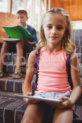 Cute little schoolgirl with her digital tablet