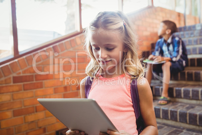 Cute little schoolgirl looking at her digital tablet
