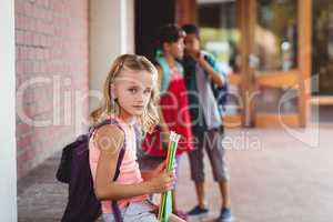 Seated blonde girl with a girl and boy in the background