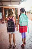 Rear view of two girls going to school