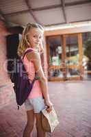 Cute little girl holding her launch bag