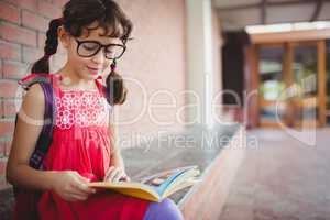 Seated schoolgirl reading a book