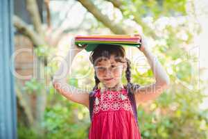 Girl holding books on her heads
