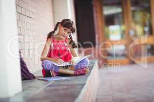 Girl writing on a book