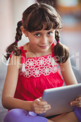 Girl with tablet looking at the camera