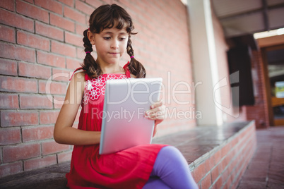 Girl sitting on a wall looking