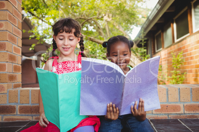 Two children holding a book