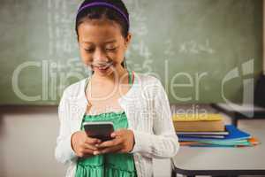 Schoolgirl smiling while holding a smartphone