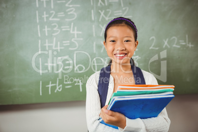 Smiling schoolgirl holding books