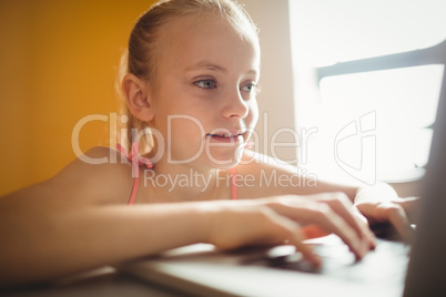 Seated girl using a computer at home
