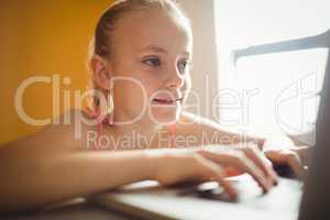 Seated girl using a computer at home