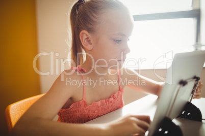 Seated girl using digital tablet