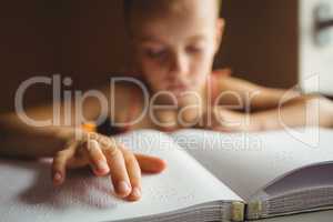 Little girl using his right hand to read braille