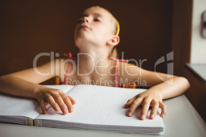Blind girl using both hands to read braille