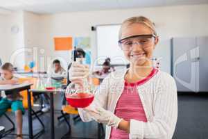 A pupil smiling at the camera with beaker