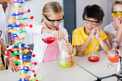 Pupil doing science while classmates looking her