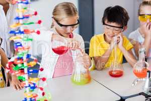 Pupil doing science while classmates looking her