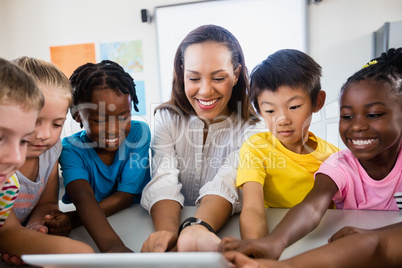 Portrait of teacher with pupil using tablet pc